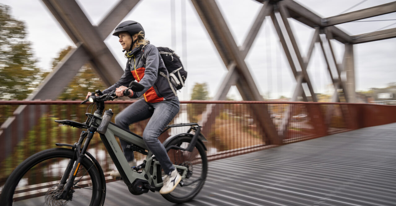 Vrouw fietst op brug