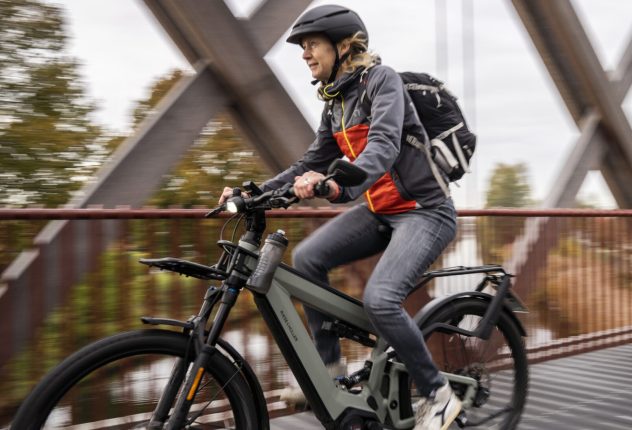 Vrouw fietst op brug