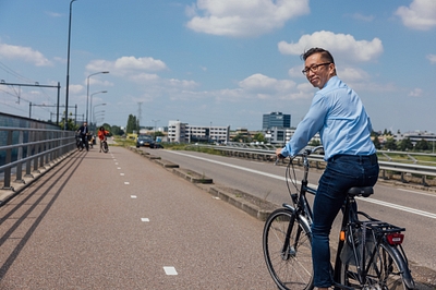 Man fietst door de Brainportregio op een stadsfiets.