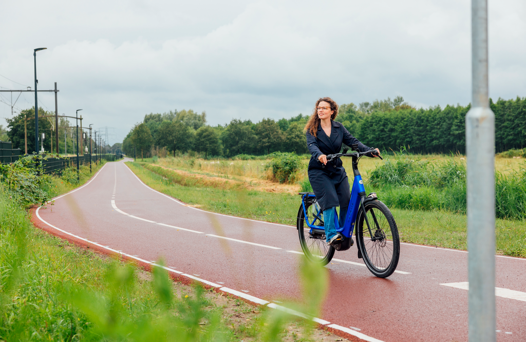 Vrouw fietst op e-bike - Brainport Bereikbaar
