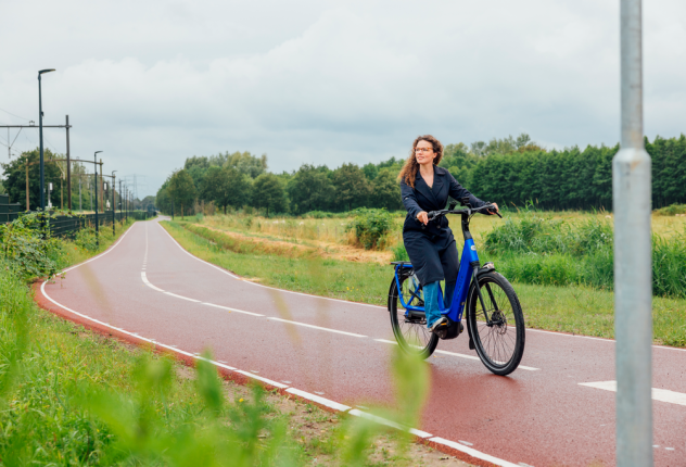 Vrouw fietst op e-bike - Brainport Bereikbaar